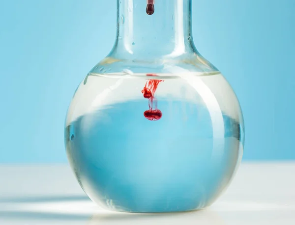 La cristalería de laboratorio y el líquido rojo en el interior en blanco — Foto de Stock