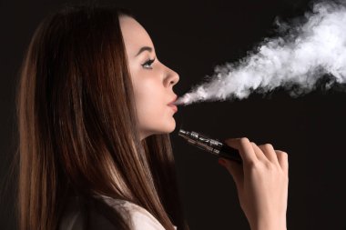 Siyah stüdyo vaping genç kadın yüzü