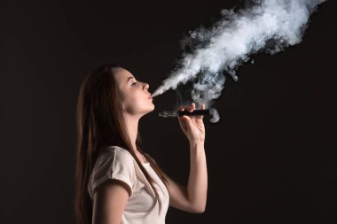Siyah stüdyo vaping genç kadın yüzü