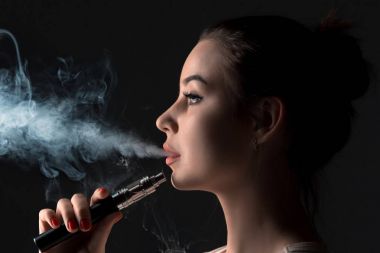 Siyah stüdyo vaping genç kadın yüzü