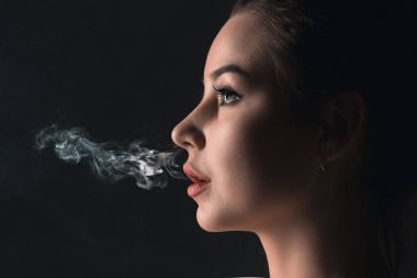 Siyah stüdyo vaping genç kadın yüzü