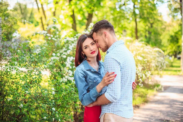 Gelukkig jong koppel in park permanent en lachen op de zonnige dag — Stockfoto