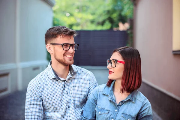 Jovem casal feliz em pé na rua da cidade e rindo no dia ensolarado brilhante — Fotografia de Stock