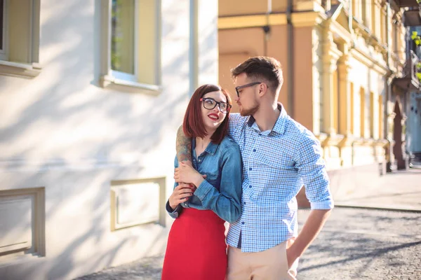 Jovem casal feliz em pé na rua da cidade e rindo no dia ensolarado brilhante — Fotografia de Stock