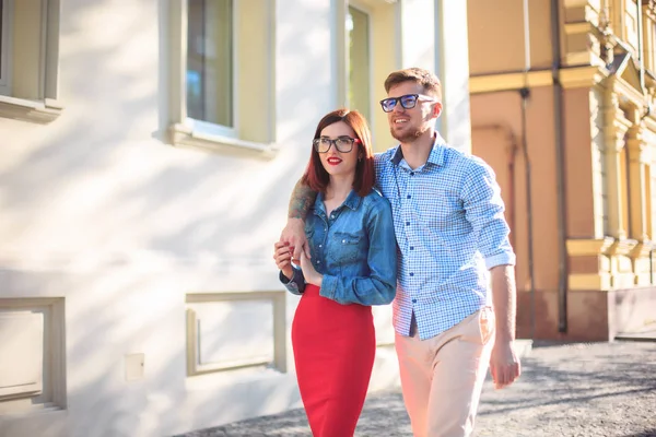 Jovem casal feliz em pé na rua da cidade e rindo no dia ensolarado brilhante — Fotografia de Stock