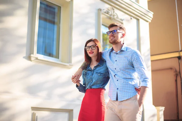 Gelukkige jonge paar staan op straat van de stad en op de zonnige dag lachen — Stockfoto