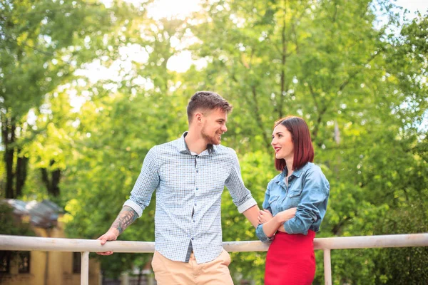 Gelukkig jong koppel in park permanent en lachen op de zonnige dag — Stockfoto