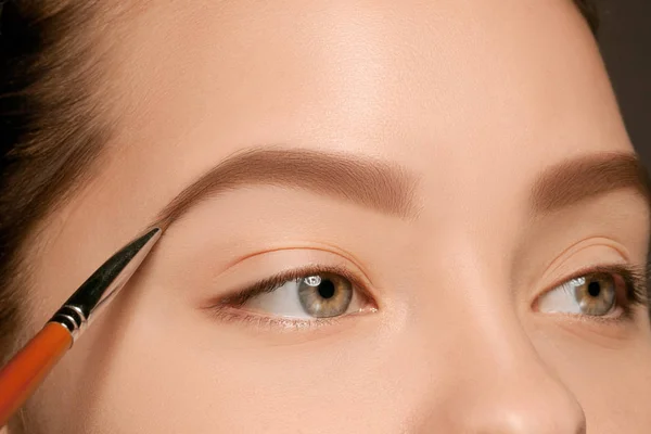 Bellissimi occhi femminili con trucco e pennello — Foto Stock