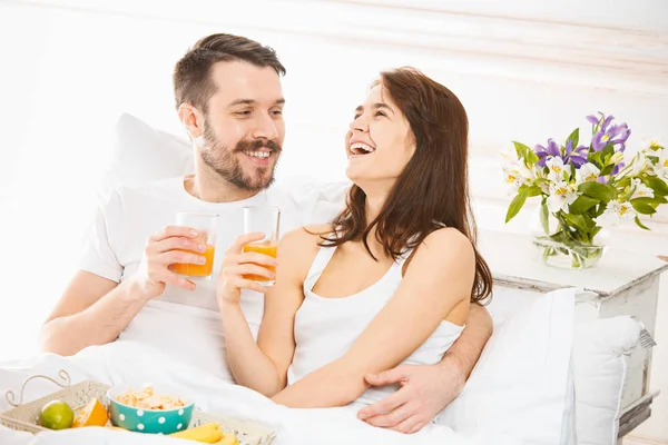 Pareja relajada en la cama en el dormitorio en casa — Foto de Stock