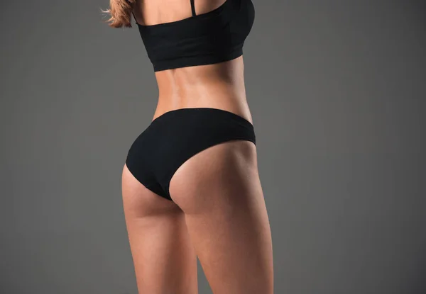 М'язиста молода жінка спортсменка на сірому — стокове фото