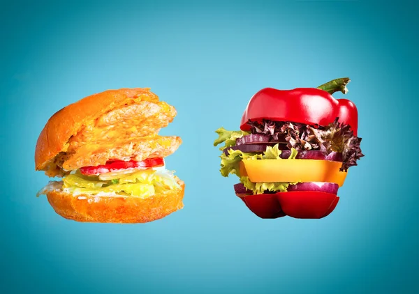 Le sandwich sain avec poivre frais, oignon, salade de laitue et hamburger nocif malsain — Photo