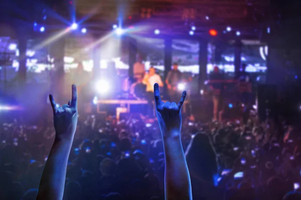 As silhuetas da multidão de concertos na frente de luzes de palco brilhantes — Fotografia de Stock