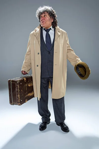 Starší muž jako detektiv nebo šéfa mafie na šedé studio pozadí — Stock fotografie