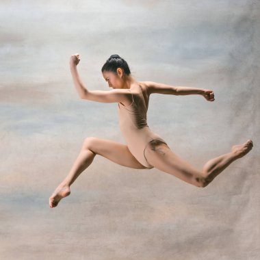genç güzel modern stil dansçı bir stüdyo arka plan üzerinde atlama