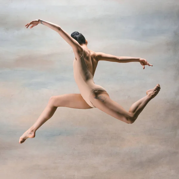 Jovem bela dançarina de estilo moderno pulando em um fundo de estúdio — Fotografia de Stock
