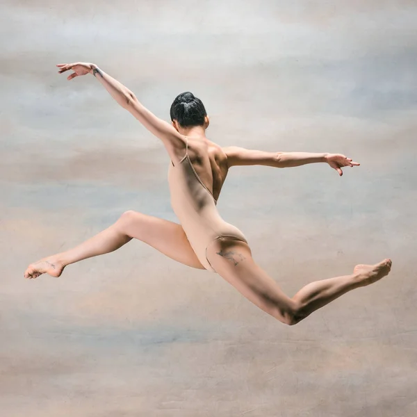 Jovem bela dançarina de estilo moderno pulando em um fundo de estúdio — Fotografia de Stock