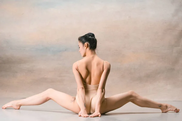 Ballerinan sitter med benen tillbaka brett isär — Stockfoto