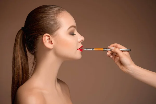 Bela lábios femininos com maquiagem e escova — Fotografia de Stock