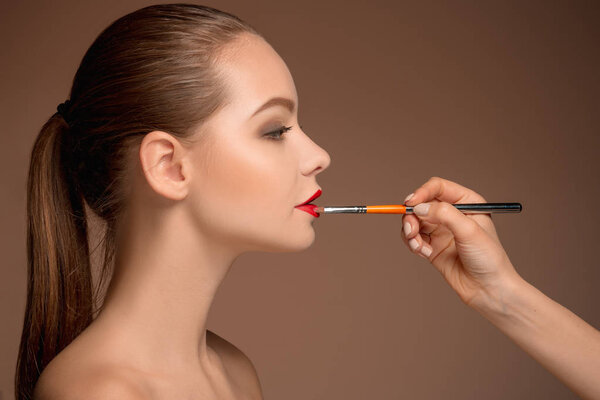 Beautiful female lips with make-up and brush