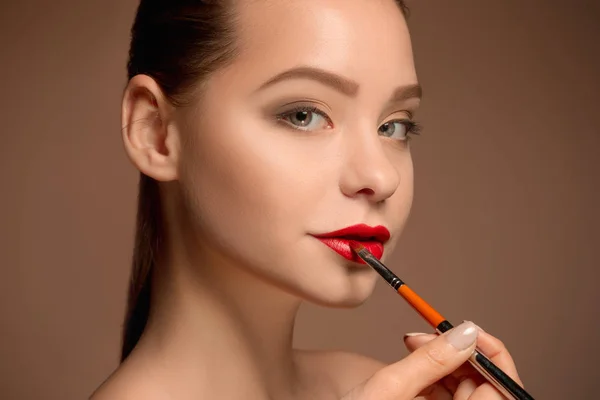 Beautiful female lips with make-up and brush — Stock Photo, Image
