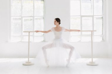 Genç ve inanılmaz güzel balerin poz ve beyaz bir stüdyoda dans