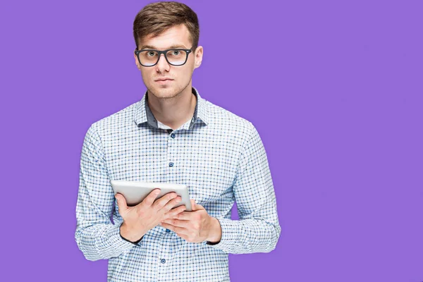 Il giovane in camicia che lavora su computer portatile su sfondo lilla in — Foto Stock