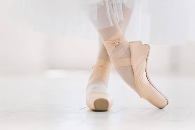 Genç balerin, closeup bacaklar ve ayakkabı, pointe pozisyonda ayakta.