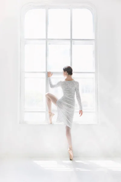 Jeune et incroyablement belle ballerine pose et danse dans un studio blanc — Photo