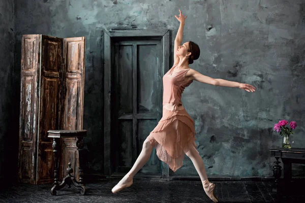Jovem e incrivelmente bela bailarina está posando e dançando em um estúdio preto — Fotografia de Stock