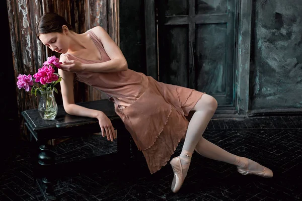 Молодая и невероятно красивая балерина позирует в черной студии — стоковое фото