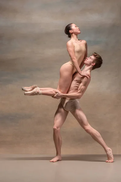 Pár baletních tanečníků vystupují nad šedým pozadím — Stock fotografie