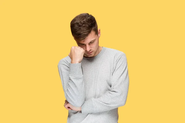 Müder Geschäftsmann oder der ernsthafte junge Mann mit gelbem Studiohintergrund mit Kopfschmerzgefühlen — Stockfoto