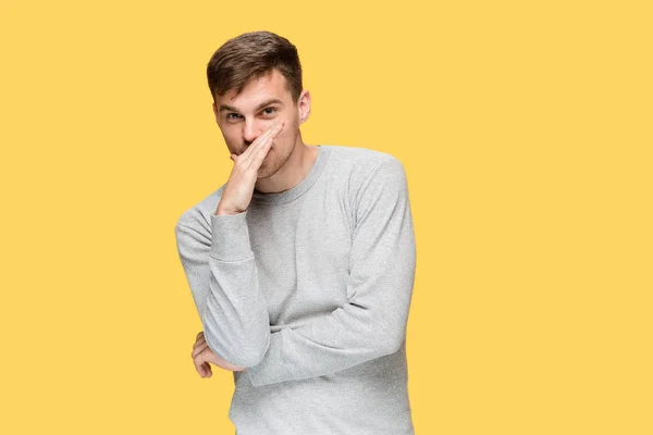 Der junge ernste Mann schaut vorsichtig und spricht geheimnisvoll — Stockfoto