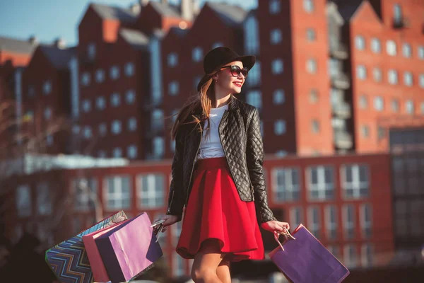 A menina que anda com compras nas ruas da cidade — Fotografia de Stock