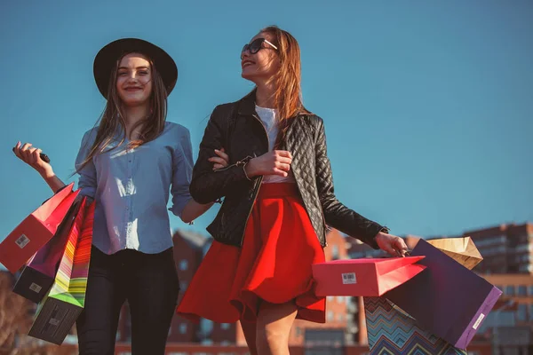 To piger går med shopping på byens gader - Stock-foto