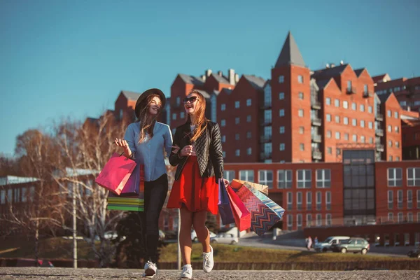 Twee meisjes lopen met winkelen op stadsstraten — Stockfoto