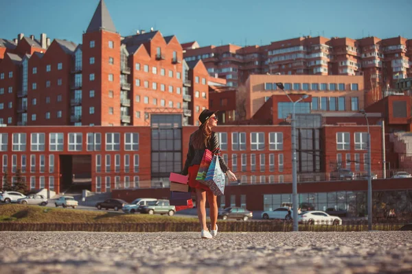 La chica caminando con las compras en las calles de la ciudad — Foto de Stock