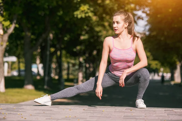 Fit mujer fitness haciendo ejercicios de estiramiento al aire libre en el parque —  Fotos de Stock
