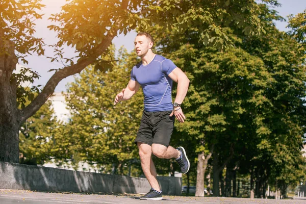 Um homem a correr no parque de manhã. Conceito de estilo de vida saudável — Fotografia de Stock