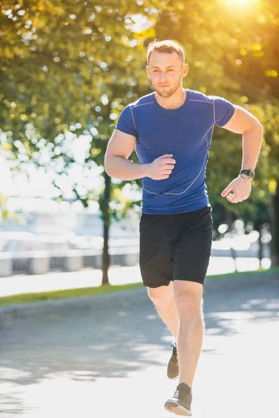 Um homem a correr no parque de manhã. Conceito de estilo de vida saudável — Fotografia de Stock