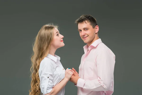 Portrait d'un jeune couple debout sur fond gris — Photo