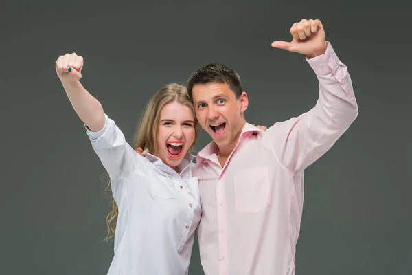 Portrait d'un jeune couple debout sur fond gris — Photo