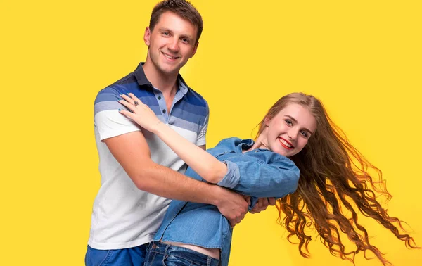 Portrait d'un jeune couple debout sur fond jaune — Photo