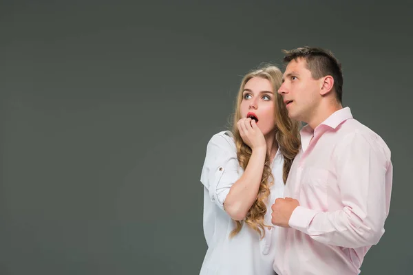 Retrato de una joven pareja de pie sobre fondo gris —  Fotos de Stock