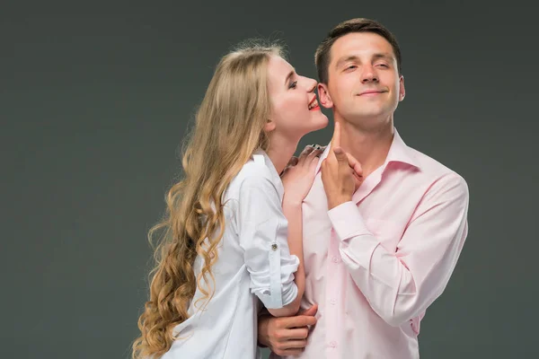 Portrait d'un jeune couple debout sur fond gris — Photo