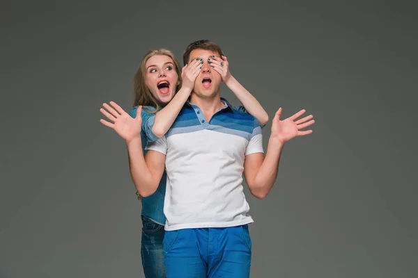 Retrato de una joven pareja de pie sobre fondo gris — Foto de Stock