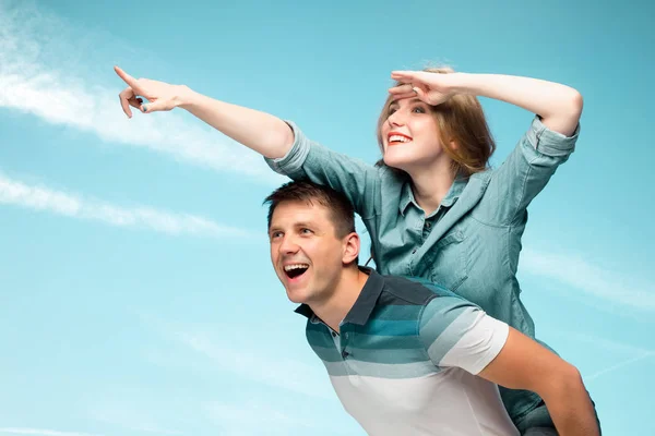 在蓝蓝的天空下微笑的年轻夫妇 — 图库照片