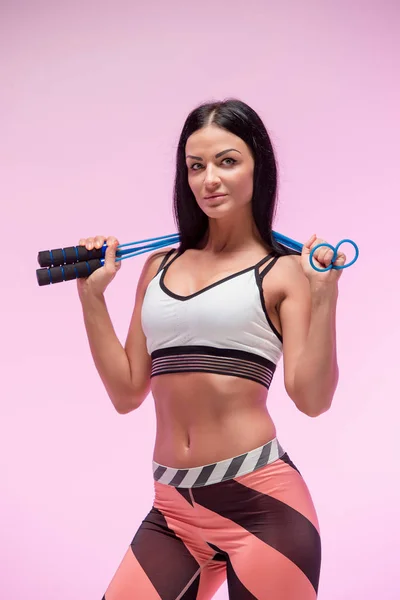 La mujer entrenando contra estudio rosa con cuerda de salto — Foto de Stock