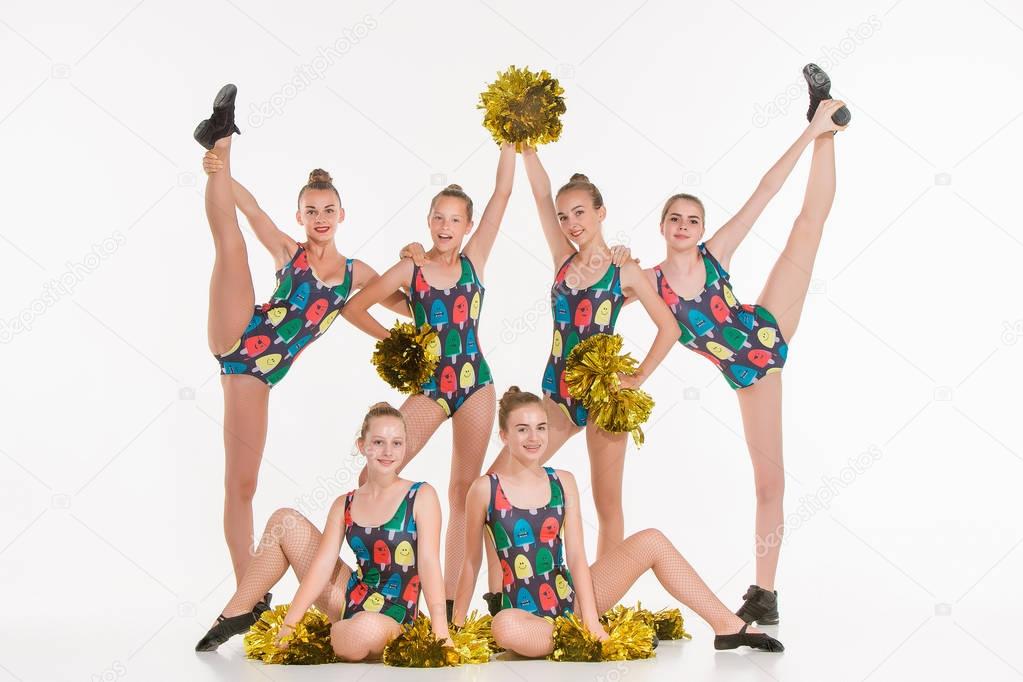 The group of teen cheerleaders posing at white studio