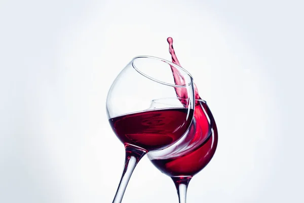 Two wine glasses in toasting gesture with big splashing. — Stock Photo, Image